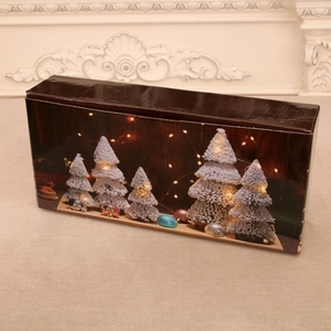 Detail of a brown gift box with lit Christmas trees and warm festive light decorations