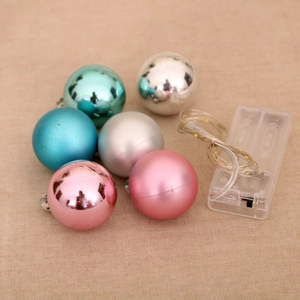 Close-up of six colorful LED Christmas ball lights on a beige textured background
