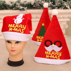 Three festive Christmas hats with snowman and tree appliques on a white fireplace set