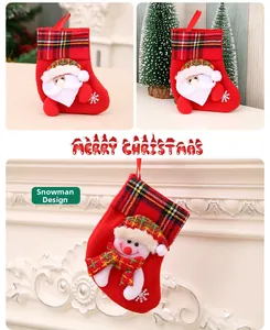 Detail view of red plush Christmas stockings with Santa and snowman plaid patterns