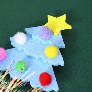 Detailed view of light blue felt Christmas tree headband with colorful pom-poms and star