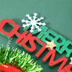 Close-up of glittery Merry Christmas headband with red green letters and white snowflake