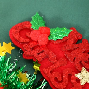 Macro detail of Merry Christmas headband with red glitter letters and festive star springs