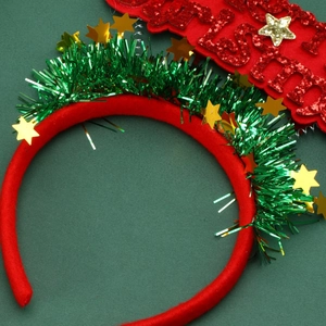 Close-up of a Christmas headband with green tinsel and gold stars on a red fabric base