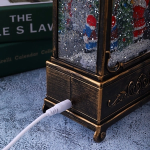 Detail of vintage Christmas lantern showing USB power cable and bronze relief base