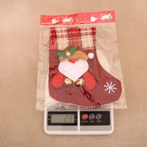 Détail d'une chaussette de Noël en toile avec poupée Père Noël et clochettes dorées