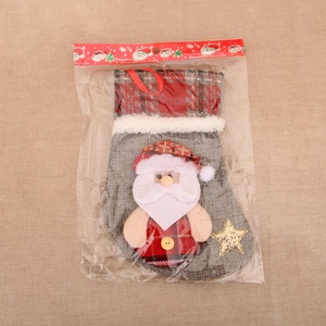 Détail d'une chaussette de Noël avec Père Noël 3D et motifs à carreaux emballée
