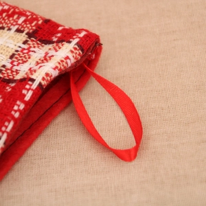 Détail d'une chaussette de Noël en tricot rouge avec boucle de suspension en satin doux