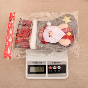 Détail d'une chaussette de Noël à carreaux avec Père Noël sur une balance
