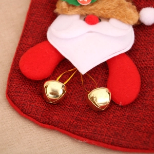 Détail d'une chaussette de Noël en lin avec figurine du Père Noël et grelots dorés