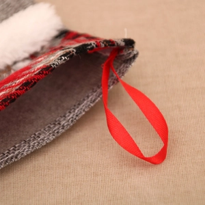 Gros plan d'une chaussette de Noël avec boucle de suspension en soie rouge et bord en fausse fourrure