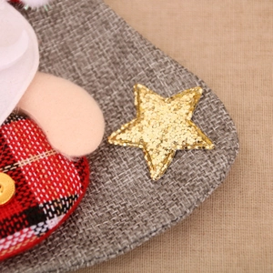 Détail du tissu à carreaux rouge et noir avec une étoile à paillettes dorées sur une botte