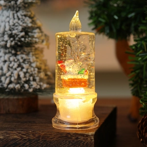 Close-up of a festive LED candle with Santa Claus miniature and silver glitter swirls