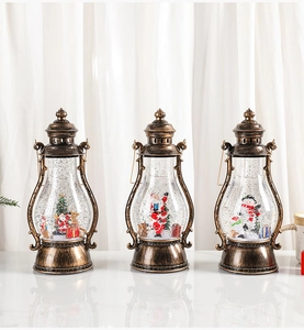 Detalle de tres faroles navideños de bronce vintage con escenas de nieve y efecto de brillo