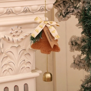 Détail d'un ornement sapin de Noël en peluche marron avec clochette dorée sur un manteau