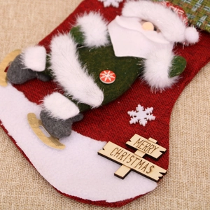 Detail of red knitted Christmas stocking with 3D skiing Santa and Merry Christmas plaque