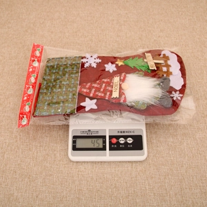 Detailed view of 45g burlap Christmas stocking with 3D gnome design on a scale