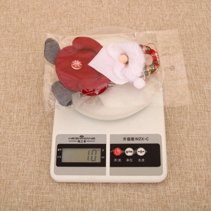 Detailed view of Santa fabric ornament weighing 10g on a scale for Christmas decor