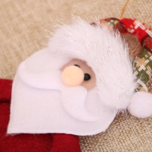 Detail view of handmade Santa fabric ornament with colorful buttons and fuzzy textures