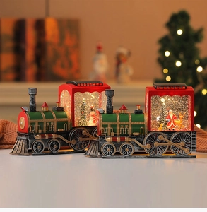 Close-up of vintage Christmas train decorations featuring Santa and snowman glitter globes