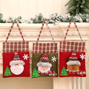 Drei Weihnachts-Geschenkbeutel aus Filz mit Weihnachtsmann, Schneemann und Rentier am Kamin