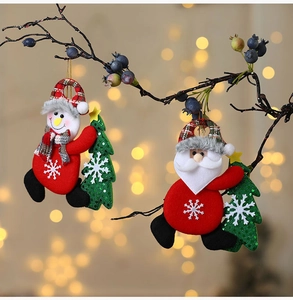 Dettaglio di addobbi natalizi in tessuto con Babbo Natale e pupazzo di neve su rami