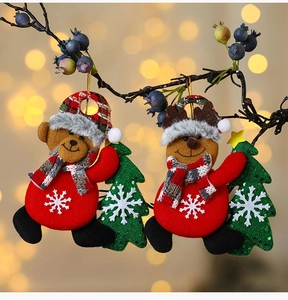 Dettaglio di decorazioni natalizie in peluche con motivi di orsetto e renna per l'albero