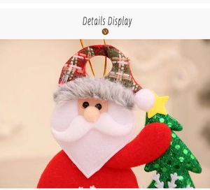 Dettaglio di un babbo natale di peluche con un albero di Natale di paillettes verdi