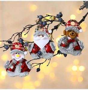 Close-up of plush Christmas ornaments with Santa, snowman and bear on tree branches