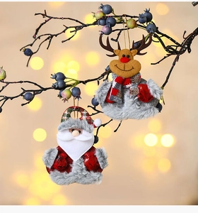 Christmas plush ornaments with Santa and reindeer on berries branch with bokeh light