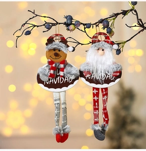 Close-up of fabric Santa and Reindeer ornaments with Navidad wood signs on a tree