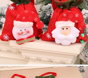 Detail of Christmas gift bags with plush Santa and snowman designs on a festive mantel