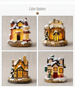 Detail of four light-up resin Christmas miniature houses with warm LED lighting and snow texture