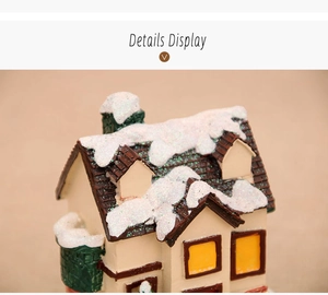 Detailed view of miniature Christmas house with snow-effect glitter and warm yellow windows