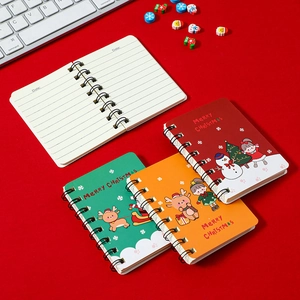 Mini Christmas spiral notebooks with cartoon elk and snowman designs on red background