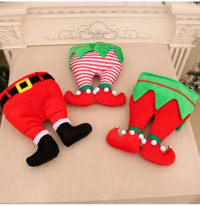 Three festive Christmas elf leg decorations with bells and boots for holiday tables