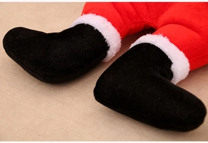 Detail of Christmas elf hat plush decor showing red fabric and black boots with fur