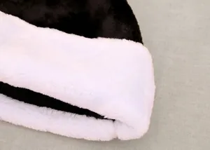 Dettaglio del pesante tessuto in peluche nero e bordo in pelliccia bianca del cappello