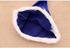 Dettaglio del cappello di Natale in peluche blu con bordo in pelliccia bianca e fodera