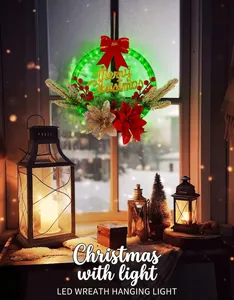 Close-up of LED Christmas wreath with red berries, pine needles and Merry Christmas sign