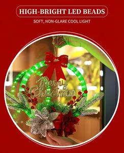 Close-up of LED glowing Christmas wreath with Merry Christmas sign and red berries