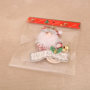 Santa Claus plush pendant with Feliz Navidad sign and festive bell in retail packaging