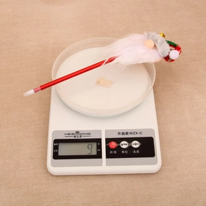 Close-up of a red Christmas ballpoint pen with a cartoon figurine and bell weighing 9g
