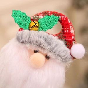 Close-up of Santa Claus plush topper with red checkered hat and golden metal bell