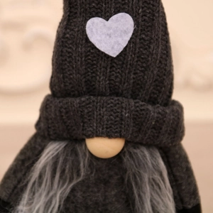 Gnome de Noël tricoté avec un cœur blanc sur chapeau gris et un nez en bois en gros plan