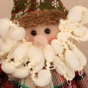 Detail of Santa Claus plush ornament featuring a textured plaid hat and fluffy pompom beard