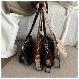 Showcasing four colors of large shoulder bags with stylish geometric woven straps