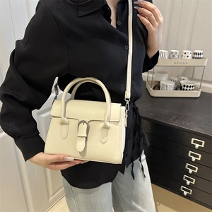 Vintage cream faux leather crossbody handbag with silver buckle and top handle styling