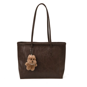 Brown leather tote bag with vintage texture and cute dog pendant in front view