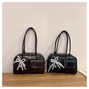 Détail de sacs à bandoulière en similicuir avec pendentif nœud en dentelle et poches
